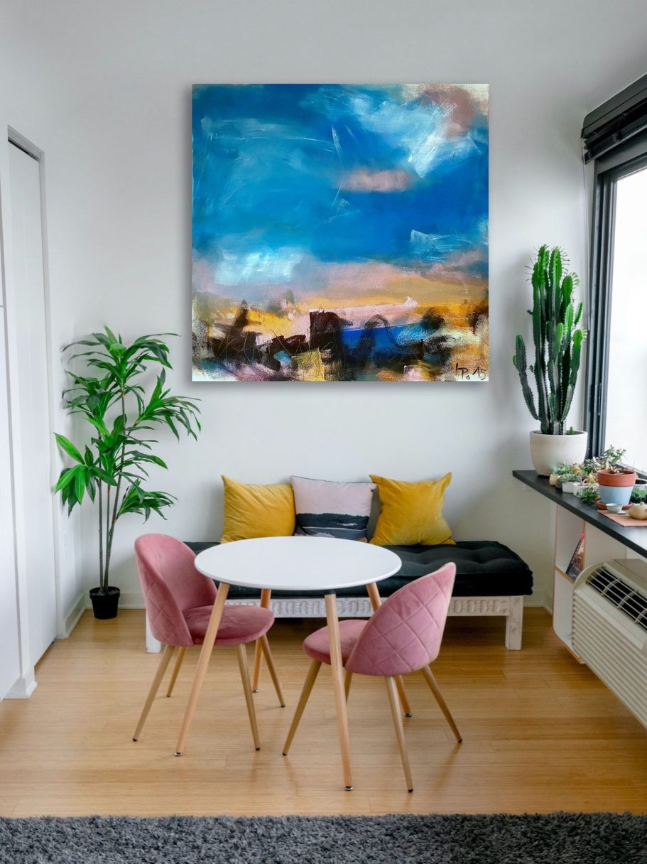Moderne Sitzecke mit runden Tisch, pinken Stühlen und buntem Gemälde an der Wand.