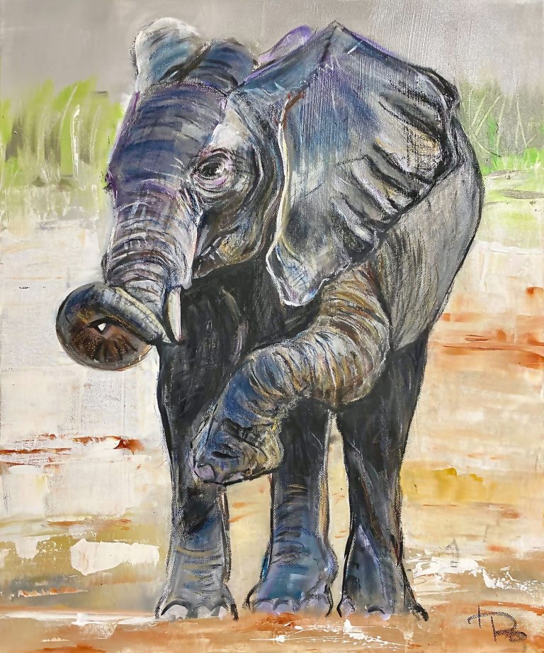 Bunter Elefant mit herausgestrecktem Rüssel steht auf einer sandigen Fläche.