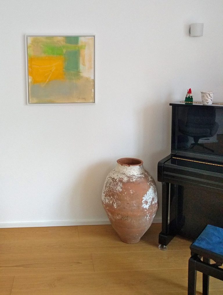 Abstraktes Gemälde über einer großen, verzierten Tonschale neben einem Klavier.